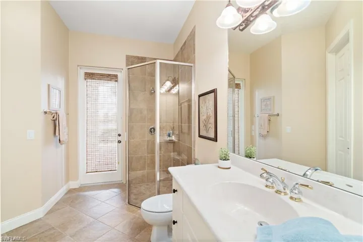 Bathroom with vanity, a stall shower, and light tile patterned floors