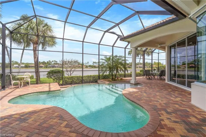 Swimming pool featuring a patio area, a sunroom, glass enclosure, and outdoor dining area