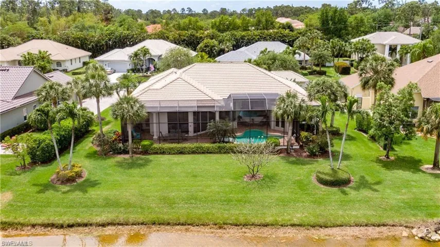 Back of property with a residential view, glass enclosure, and an outdoor pool