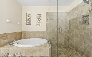 Bathroom with a shower stall and a bath
