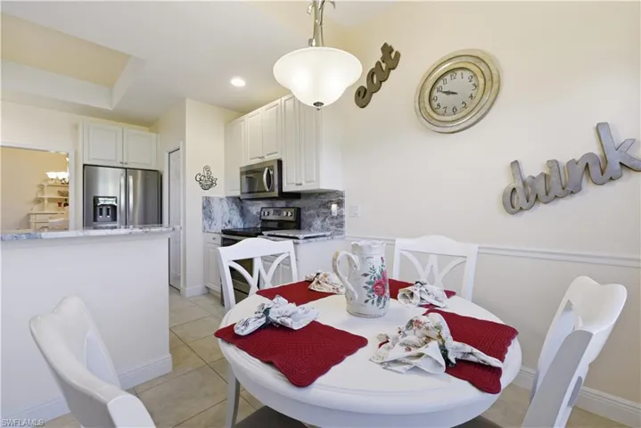 Dining room with light tile patterned flooring and recessed lighting