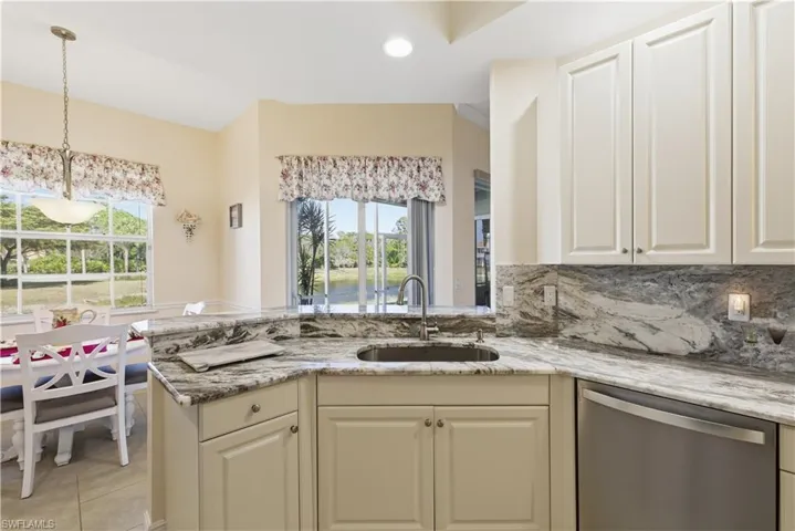 Kitchen with dishwasher, light stone countertops, pendant lighting, a peninsula, and recessed lighting