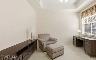 Sitting room with a raised ceiling, a skylight, and an office area