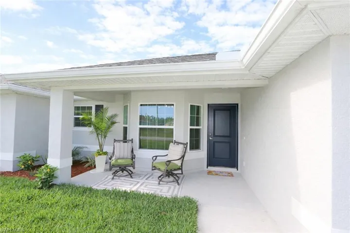The property features a welcoming front entrance with a covered porch and a dark-paneled door