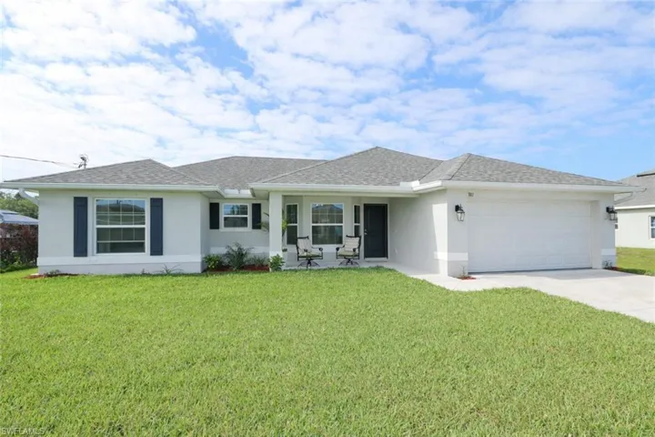 This property features a well-maintained lawn, a spacious driveway, and an attached garage