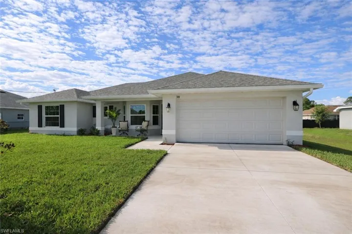 This single-story property features a light-colored stucco exterior, a gray shingle roof, and a two-car garage