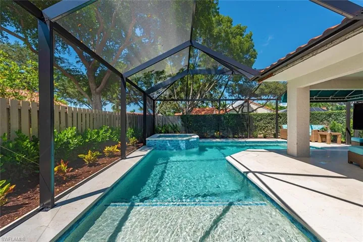 View of pool with a lanai, a sunroom, a pool with connected hot tub, and a patio area