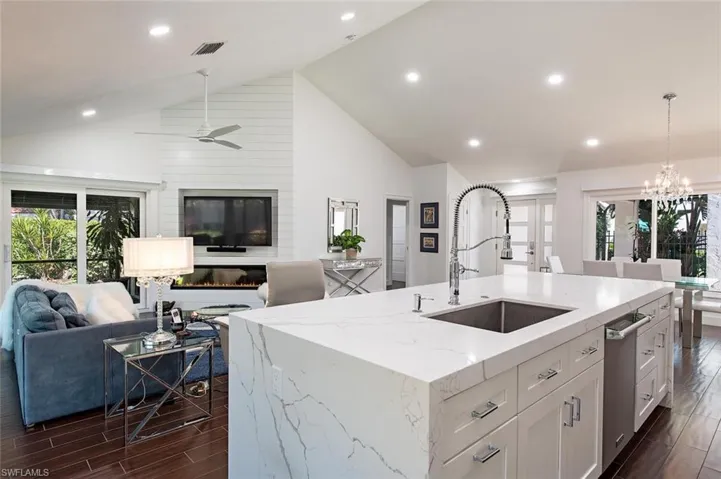Kitchen featuring plenty of natural light, wood finish floors, open floor plan, recessed lighting, and high vaulted ceiling