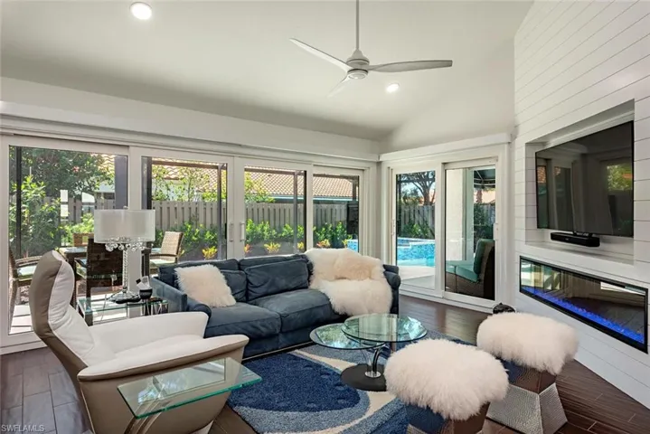 Living room featuring wood finished floors, plenty of natural light, vaulted ceiling, recessed lighting, and ceiling fan