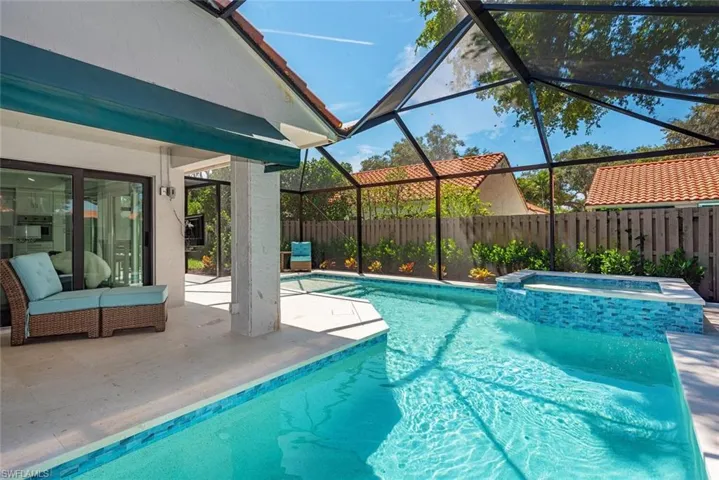View of swimming pool featuring a lanai, a patio, a pool with connected hot tub, and a sunroom