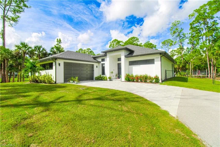 Prairie-style home featuring a garage and a front lawn