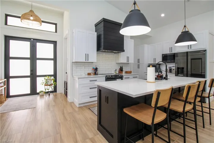 Kitchen with white cabinetry, pendant lighting, and stainless steel appliances