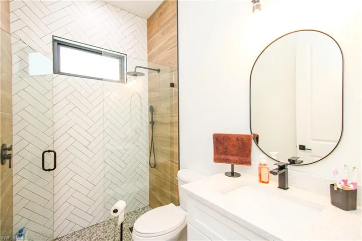 Bathroom featuring vanity, toilet, and an enclosed shower