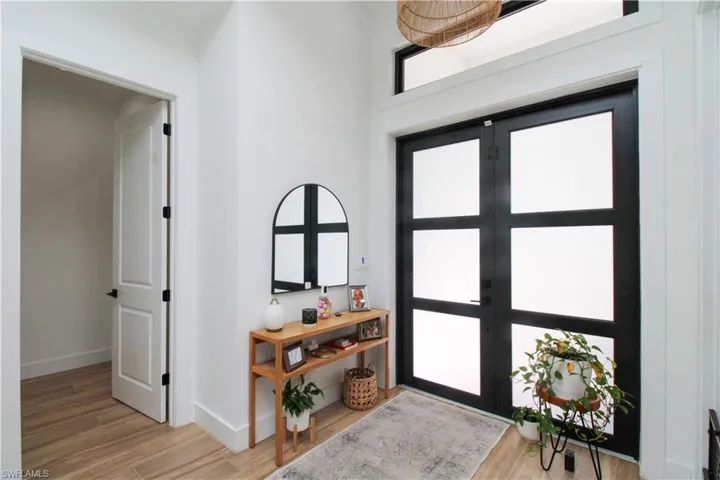 Entrance foyer with light wood-type flooring and french doors