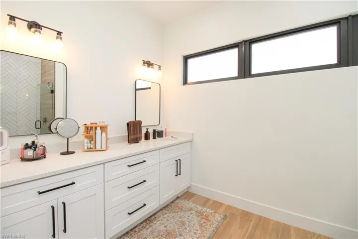 Bathroom with vanity, hardwood / wood-style floors, and an enclosed shower
