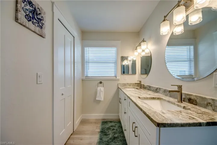 Dual vanity featuring undermount sinks, stone-finish countertops, and brushed nickel fixtures