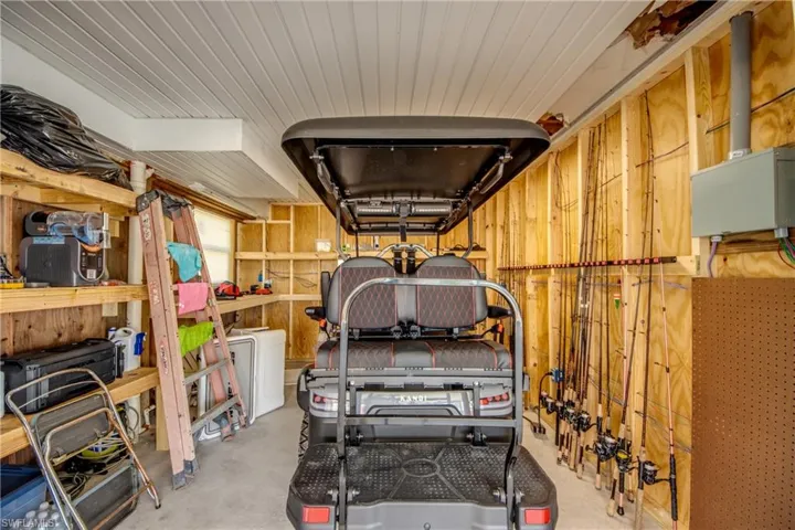 Garage space with exposed wood framing, built-in shelving, and a white paneled ceiling