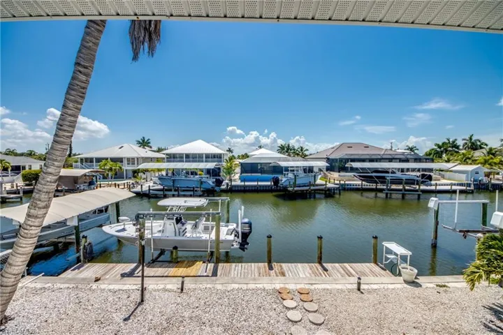 Waterfront property featuring a private dock with boat lift and covered boat slip