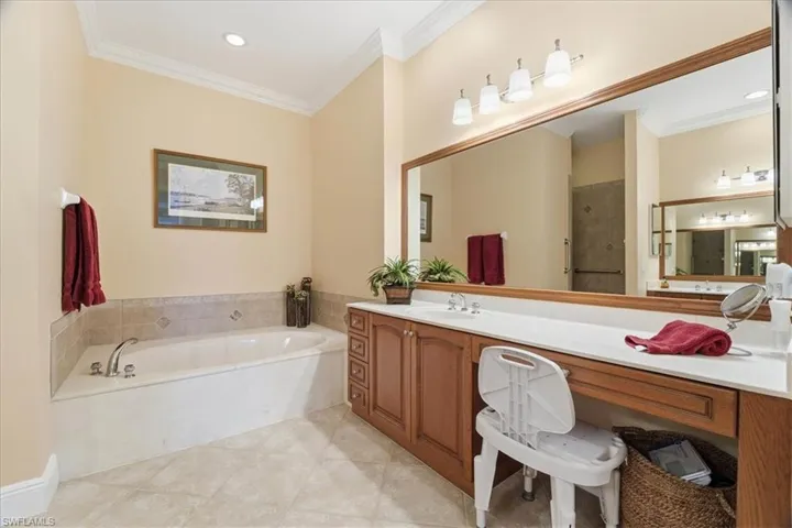 Full bathroom with a bath, vanity, crown molding, light tile patterned floors, and recessed lighting