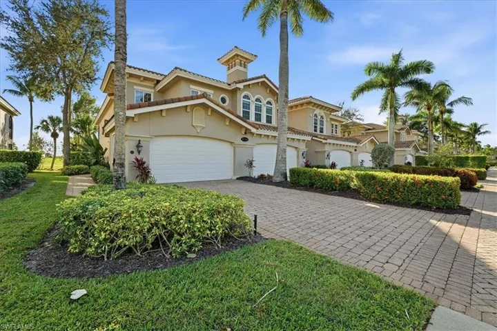 Mediterranean / spanish-style home featuring stucco siding, decorative driveway, a chimney, and a tiled roof