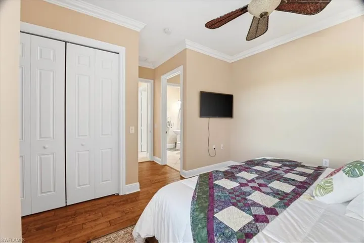 Bedroom featuring ornamental molding, wood finished floors, a closet, and a ceiling fan
