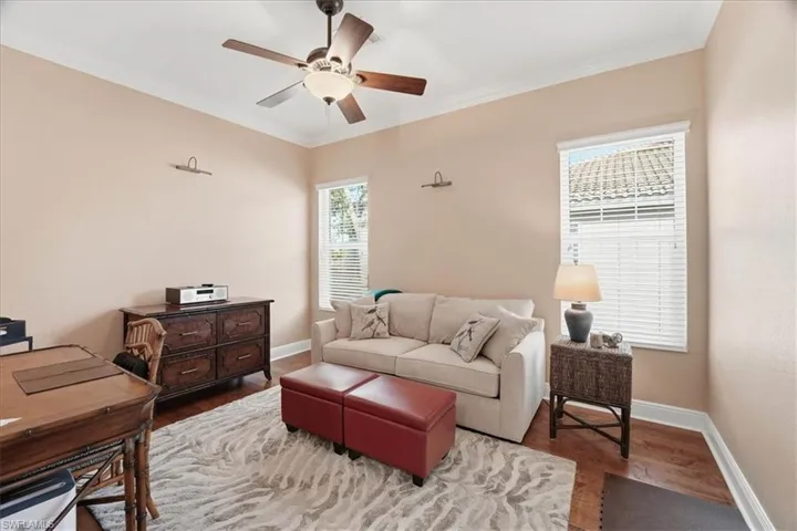 Living room with ornamental molding, ceiling fan, and wood finished floors