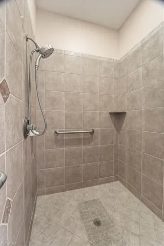 Full bath featuring tiled shower