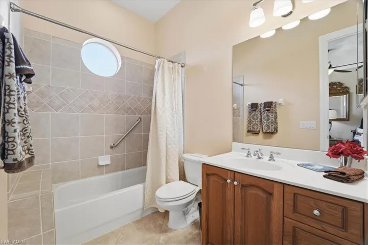 Full bath featuring vanity, shower / bath combo, and light tile patterned flooring