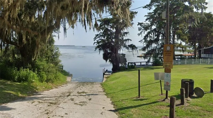 View of community with a boat ramp, a water view, and a boat dock