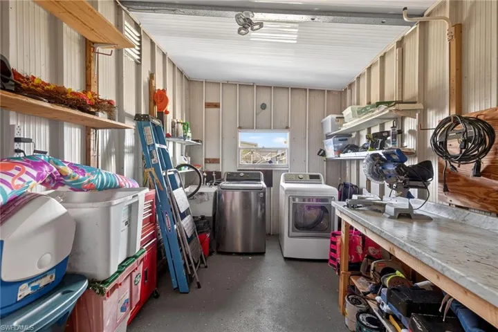 Garage featuring washer and dryer and metal wall