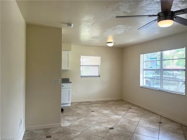 Unfurnished dining area with a ceiling fan and light tile patterned floors