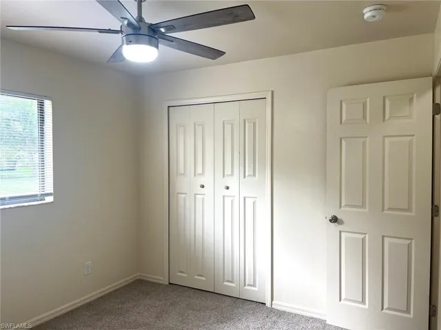 Unfurnished bedroom with carpet flooring, ceiling fan, and a closet
