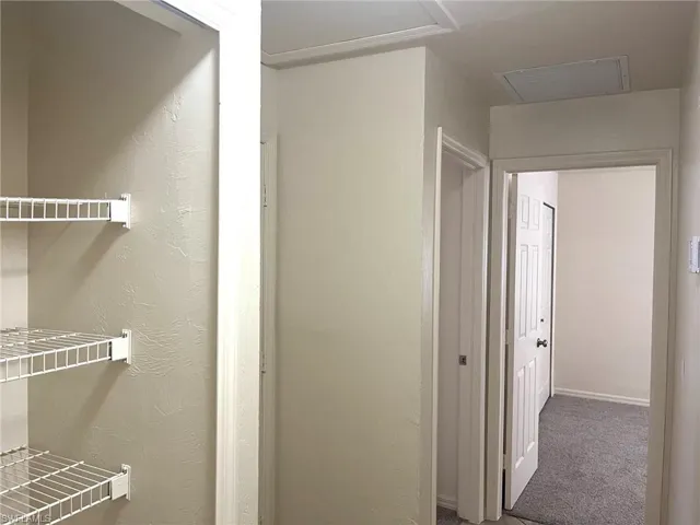 Hall with carpet and a textured wall