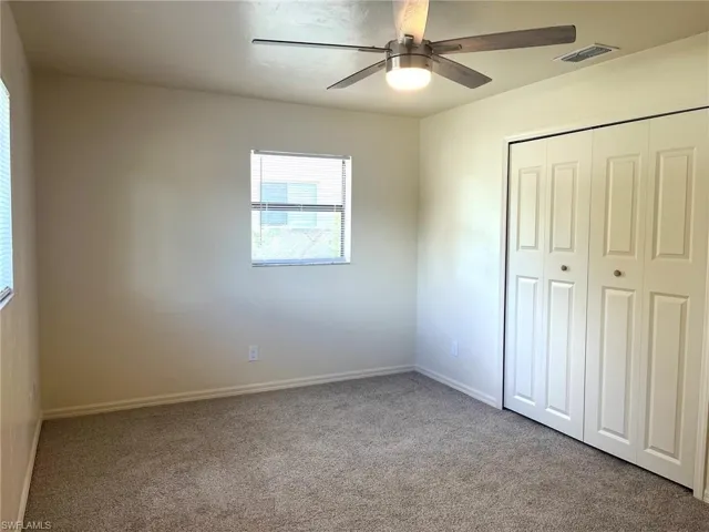 Unfurnished bedroom with carpet floors, a closet, and ceiling fan