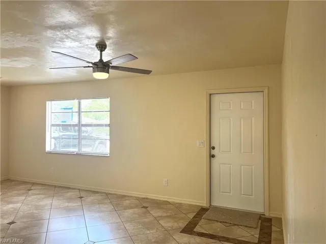 Spare room with light tile patterned flooring and a ceiling fan