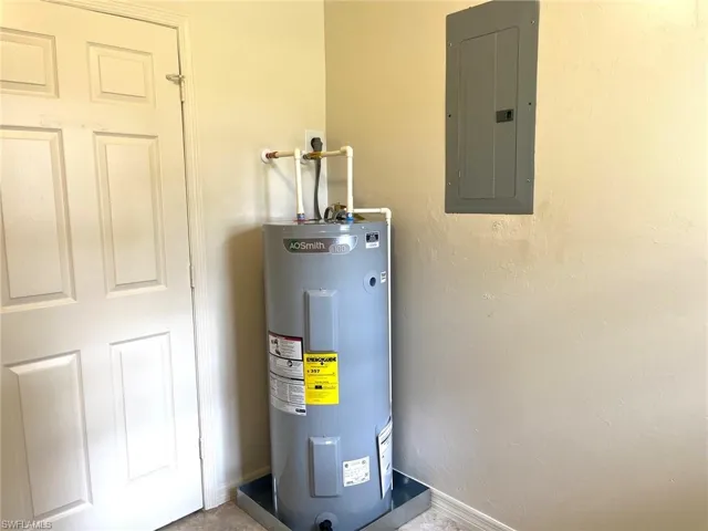 Utility room featuring electric water heater and electric panel