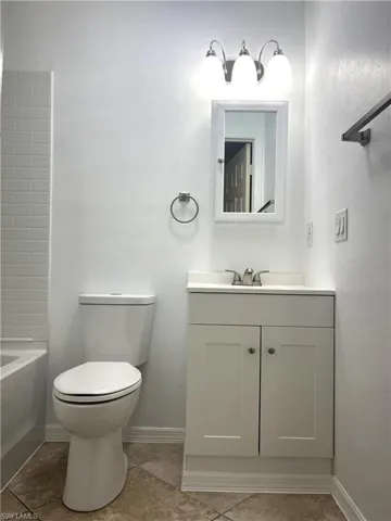 Full bathroom with vanity, light tile patterned floors, and  shower combination