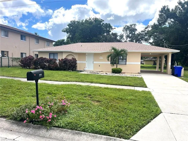 View of front of home with stucco siding, a carport, concrete driveway, and a shingled roof