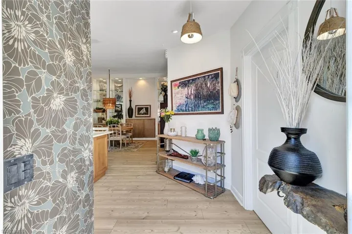 Wood-finish flooring throughout, with a decorative accent wall featuring a botanical pattern