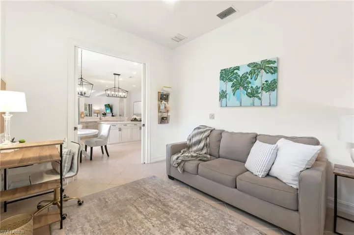 Living area featuring light tile patterned flooring and visible vents