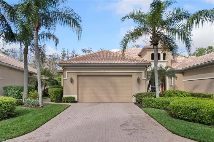 Mediterranean / spanish-style house featuring a garage, decorative driveway, a tile roof, and stucco siding