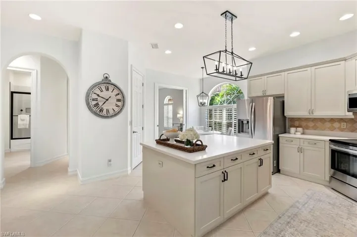 Kitchen featuring light tile patterned floors, visible vents, light countertops, appliances with stainless steel finishes, and tasteful backsplash
