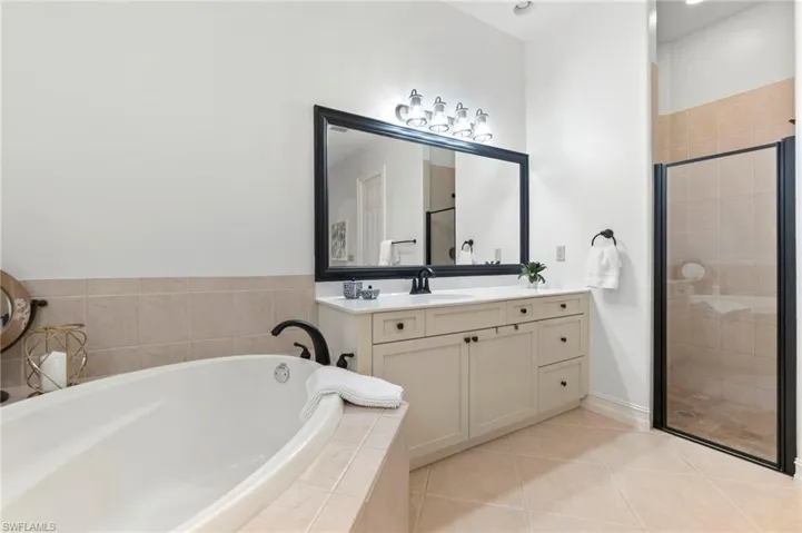 Full bathroom with a stall shower, vanity, a bath, and tile patterned floors