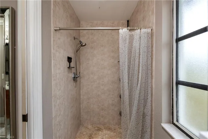Bathroom featuring a shower with curtain and plenty of natural light