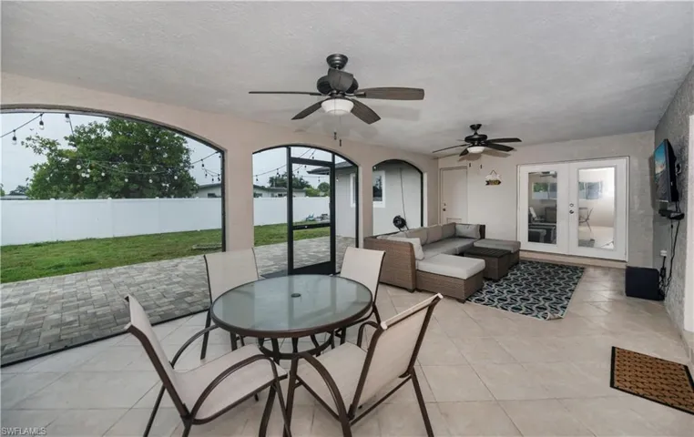View of terrace featuring ceiling fan, french doors, and a water view