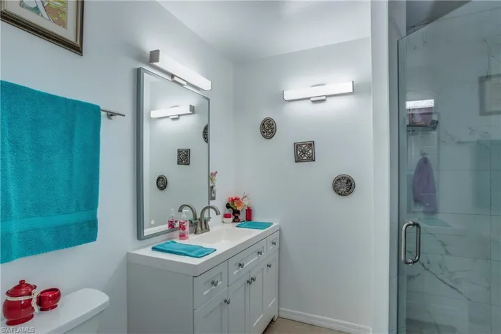 Bathroom with vanity, a stall shower, and toilet