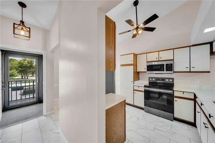 Entrance ~ front door into Kitchen featuring tile flooring, granite countertops, ceiling fan, and high vaulted ceiling, Newer Appliances