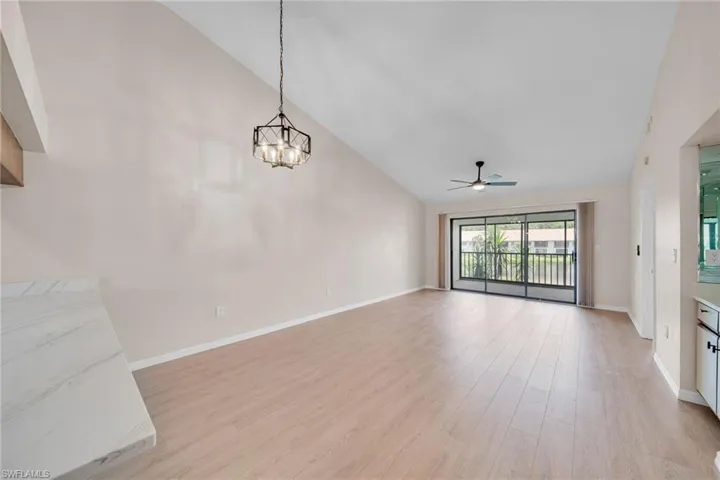 Expansive dining ~ living with high vaulted ceiling and big lake view