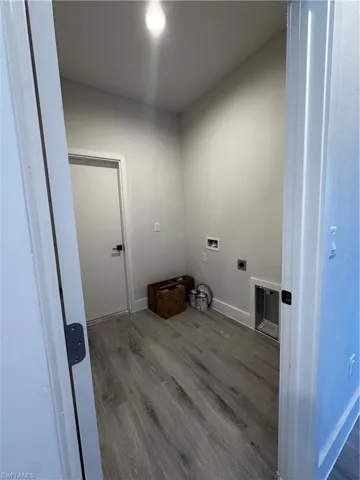 Clothes washing area featuring electric dryer hookup, hardwood / wood-style flooring, and hookup for a washing machine