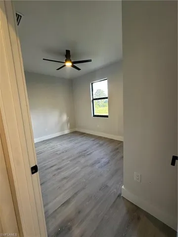 Unfurnished room featuring hardwood / wood-style flooring and ceiling fan